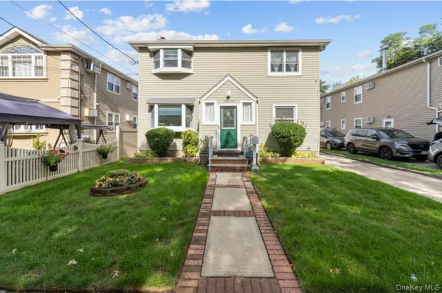 a front view of a house with a yard and potted plants