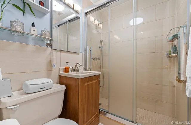 a bathroom with a granite countertop sink a toilet and shower