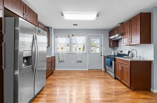 a kitchen with stainless steel appliances granite countertop a refrigerator and a sink