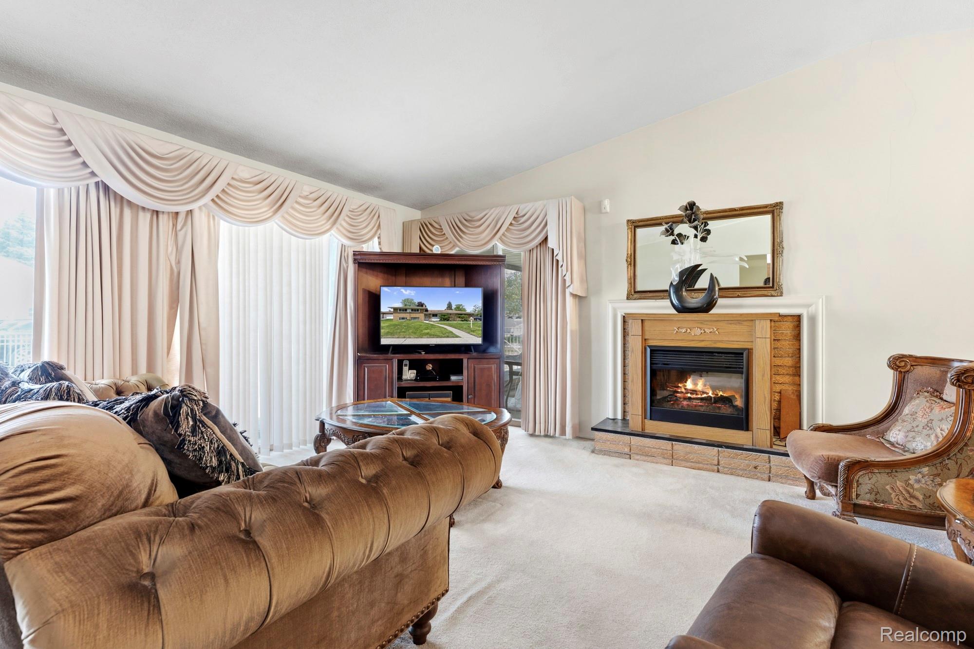 23410 Joy Road Redford, MI 48239 - Photo 9 of 25 Carpeted living room with a glass covered fireplace and vaulted ceiling