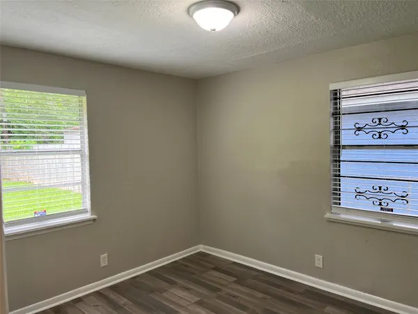 an empty room with wooden floor & closet area