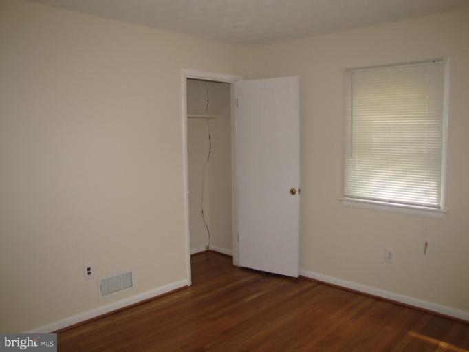 15411 Bond Mill Road Laurel, MD 20707 - Photo 21 of 26 a view of an empty room with wooden floor and a window
