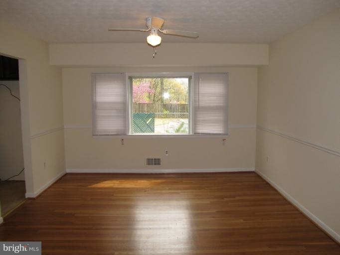 15411 Bond Mill Road Laurel, MD 20707 - Photo 23 of 26 an empty room with wooden floor and windows