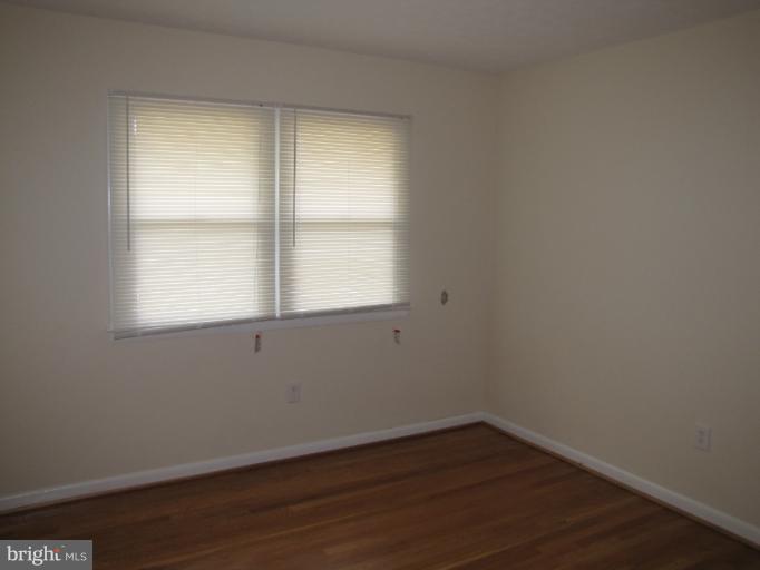 15411 Bond Mill Road Laurel, MD 20707 - Photo 25 of 26 an empty room with wooden floor and windows