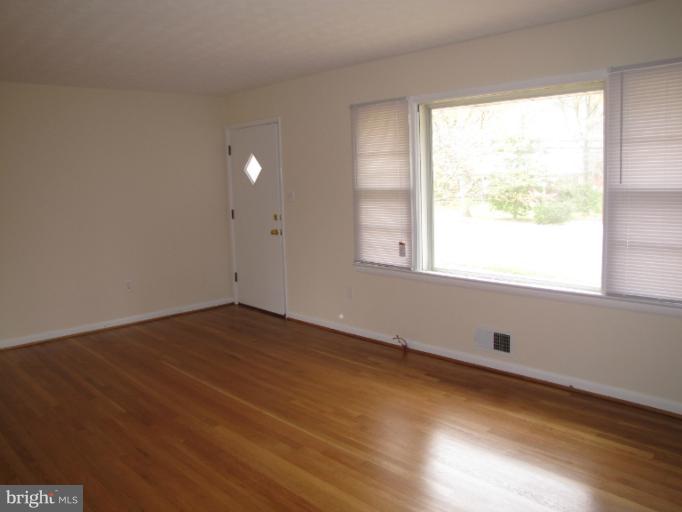 15411 Bond Mill Road Laurel, MD 20707 - Photo 4 of 26 a view of an empty room with wooden floor and a window