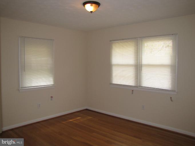 15411 Bond Mill Road Laurel, MD 20707 - Photo 7 of 26 an empty room with wooden floor and windows