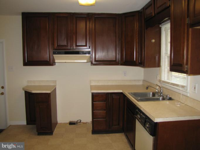 15411 Bond Mill Road Laurel, MD 20707 - Photo 10 of 26 a kitchen with wooden cabinets and a sink