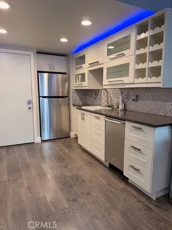 a kitchen with granite countertop a refrigerator and a sink