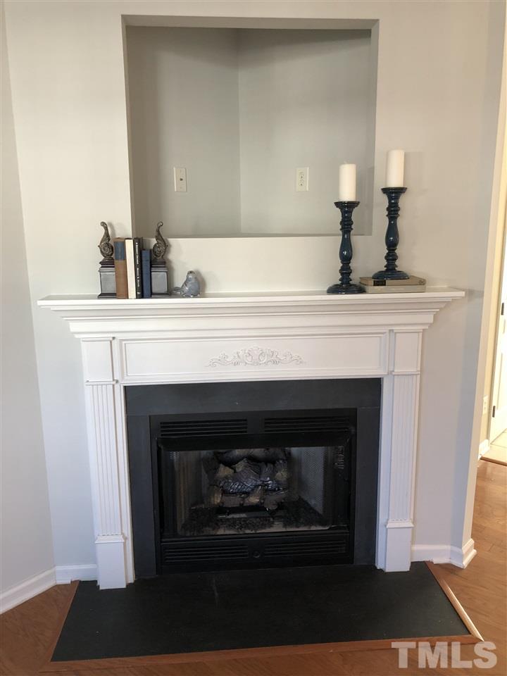 7857 Spungold Street Raleigh, NC 27617 - Photo 2 of 13 a living room with a fireplace and a lamp