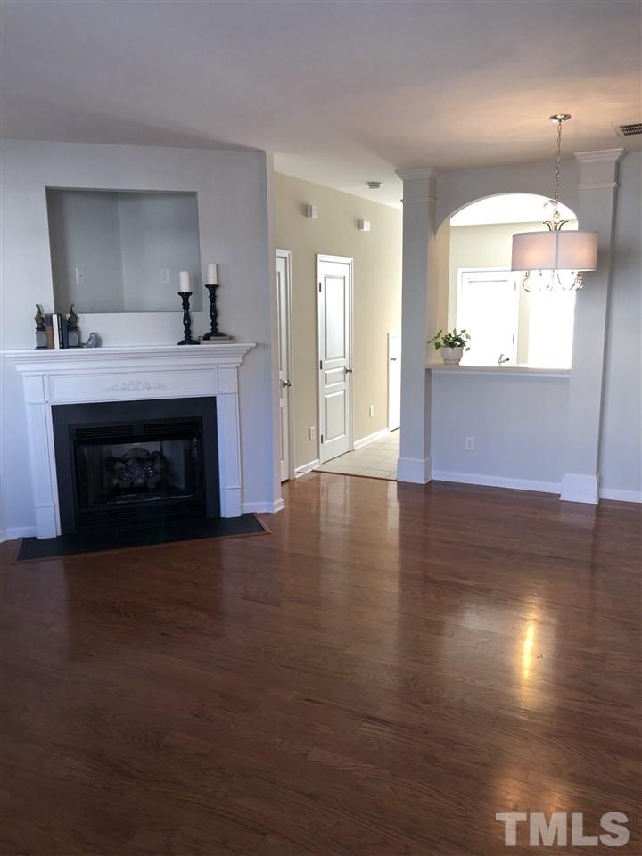 7857 Spungold Street Raleigh, NC 27617 - Photo 9 of 13 a view of an empty room with wooden floor and a fireplace