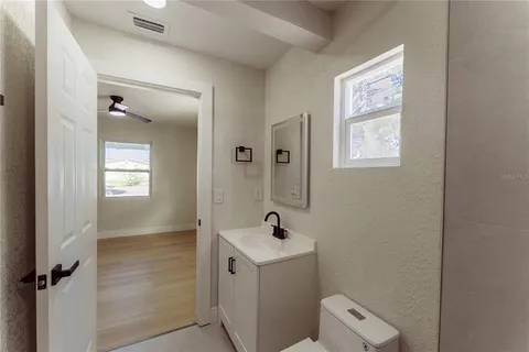 a bathroom with a sink a toilet and a mirror