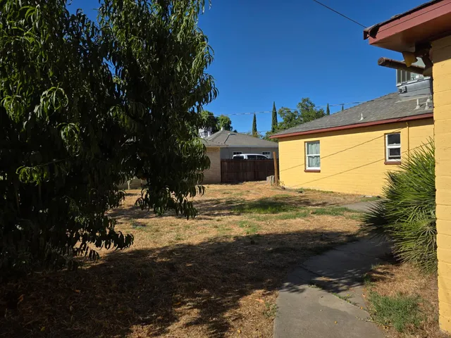 a view of a yard with wooden fence