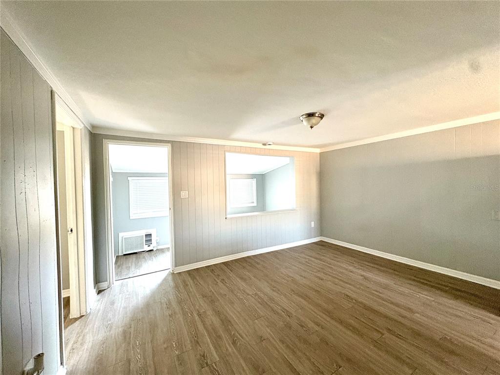 4611 North Hubert Avenue, Unit 13 Tampa, FL 33614 - Photo 5 of 9 an empty room with wooden floor and windows