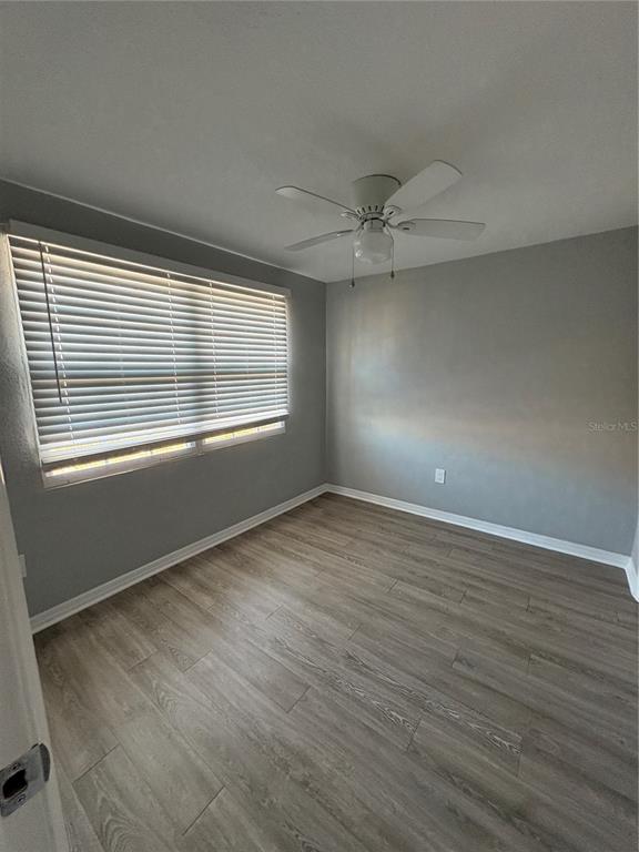 4611 North Hubert Avenue, Unit 13 Tampa, FL 33614 - Photo 9 of 9 an empty room with wooden floor and windows