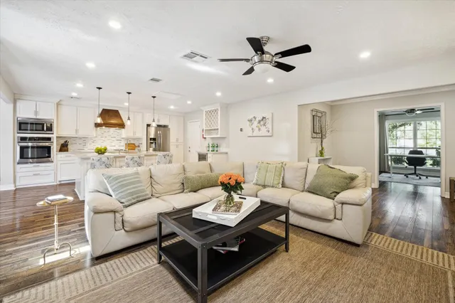 a living room with furniture and a wooden floor