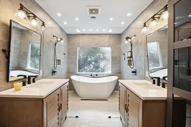 a bathroom with a double vanity sink a mirror and a bathtub