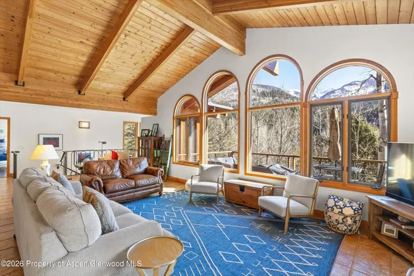 a living room with furniture a fireplace and a floor to ceiling window
