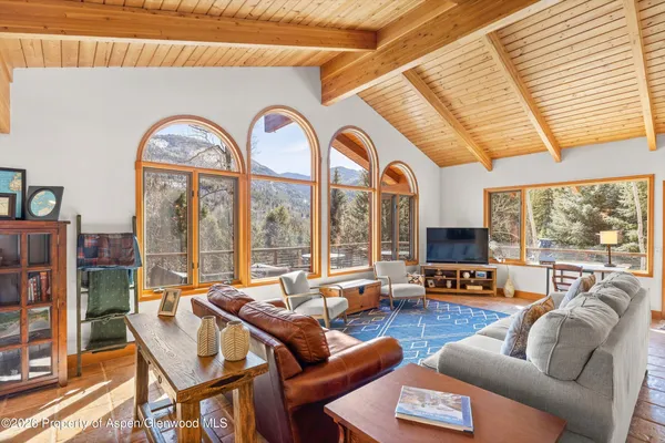 a living room with furniture a flat screen tv and a large window