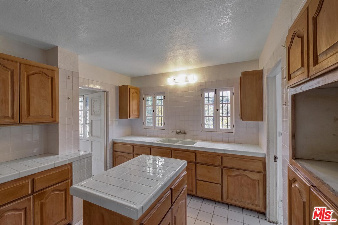 6220 Warner Drive Los Angeles, CA 90048 - Photo 20 of 44 a kitchen with a sink and cabinets