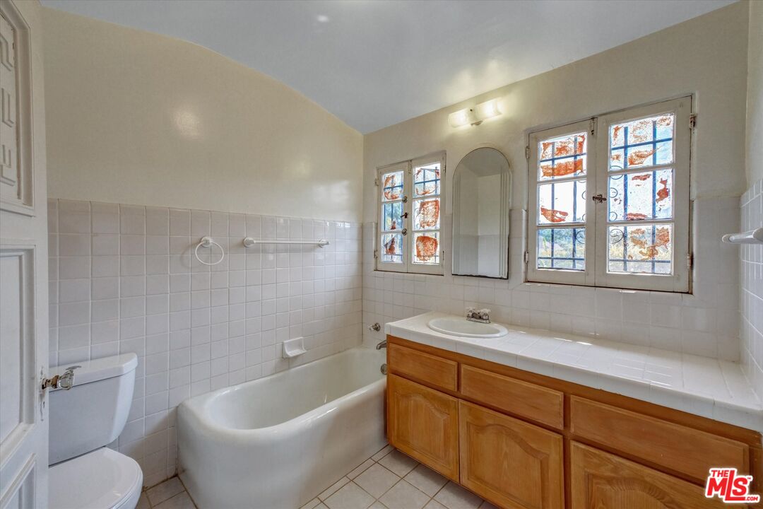 6220 Warner Drive Los Angeles, CA 90048 - Photo 34 of 44 a spacious bathroom with a toilet sink and mirror