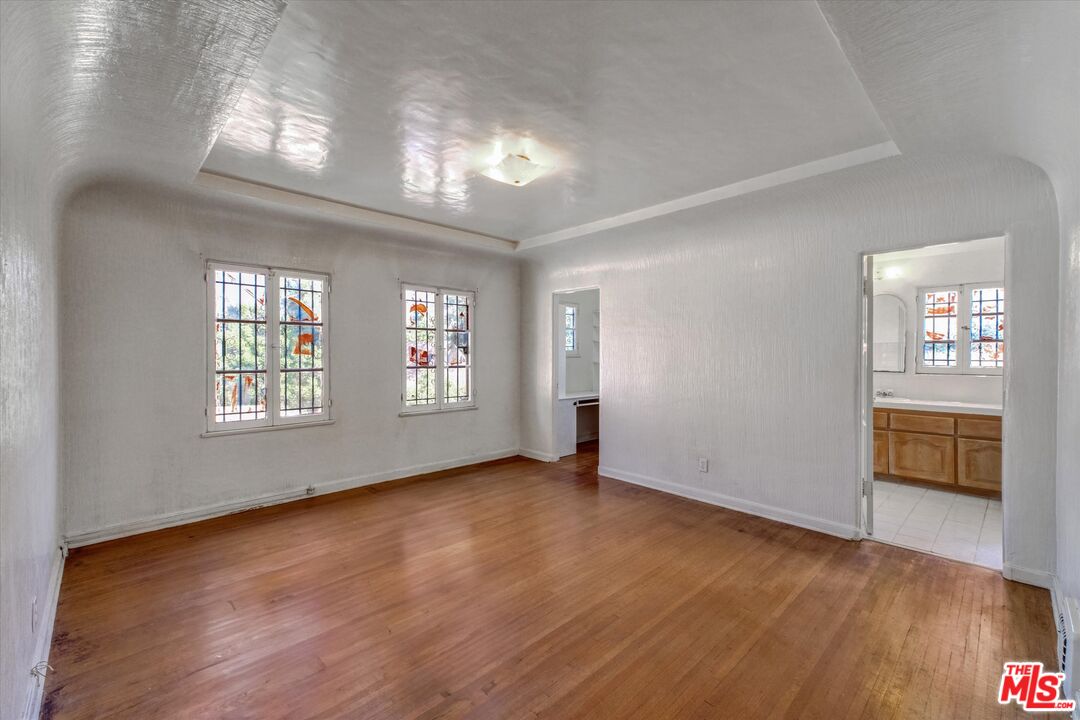 6220 Warner Drive Los Angeles, CA 90048 - Photo 35 of 44 an empty room with wooden floor and windows