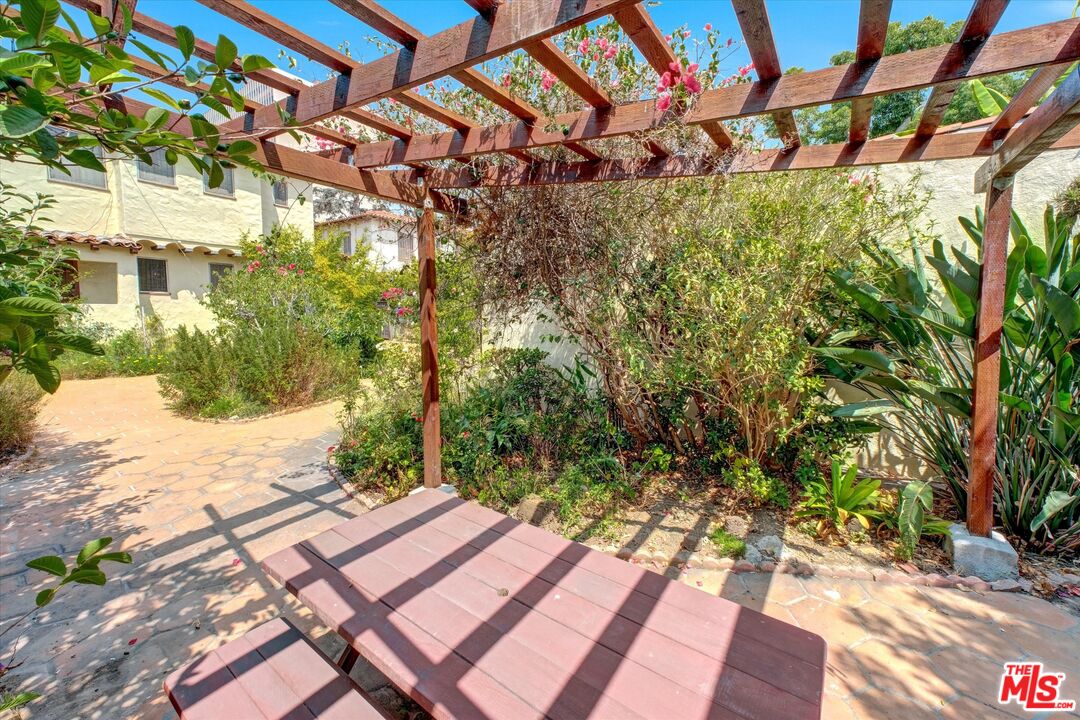 6220 Warner Drive Los Angeles, CA 90048 - Photo 39 of 44 a backyard of a house with large trees and outdoor seating