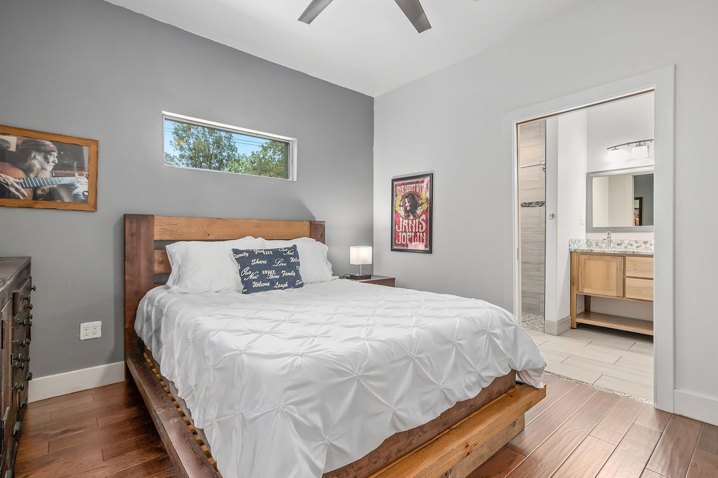 13326 Trautwein Road Austin, TX 78737 - Photo 24 of 38 Bedroom featuring light wood finished floors, baseboards, a ceiling fan, and connected bathroom