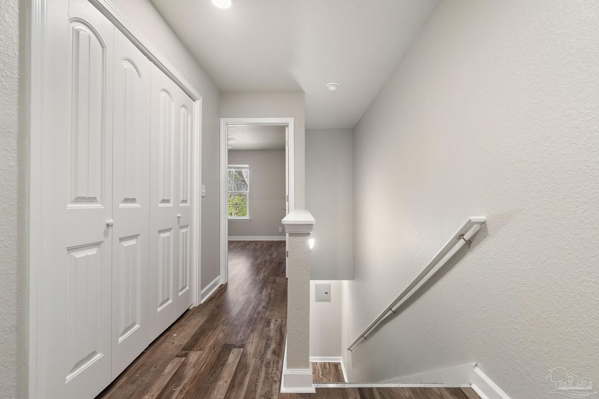 9906 Holsberry Road, Unit 101 Pensacola, FL 32534 - Photo 8 of 16 a view of a hallway with wooden floor and staircase