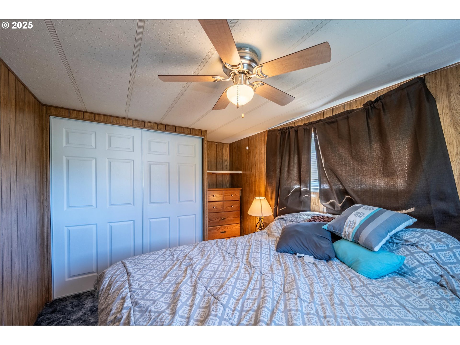 125 North 4th Street Lakeside, OR 97449 - Photo 19 of 38 a bedroom with a bed and a chandelier
