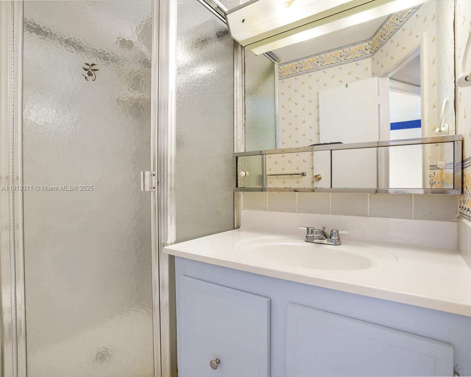 4705 Northwest 35th Street, Unit 616 Lauderdale Lakes, FL 33319 - Photo 16 of 33 a bathroom with a sink and a mirror