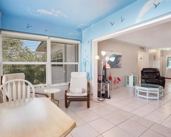 a living room with furniture a flat screen tv and large windows