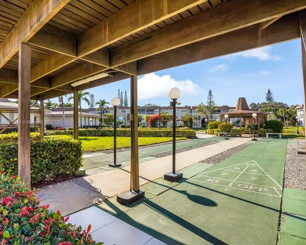 a view of a swimming pool with a chair and tables in the patio