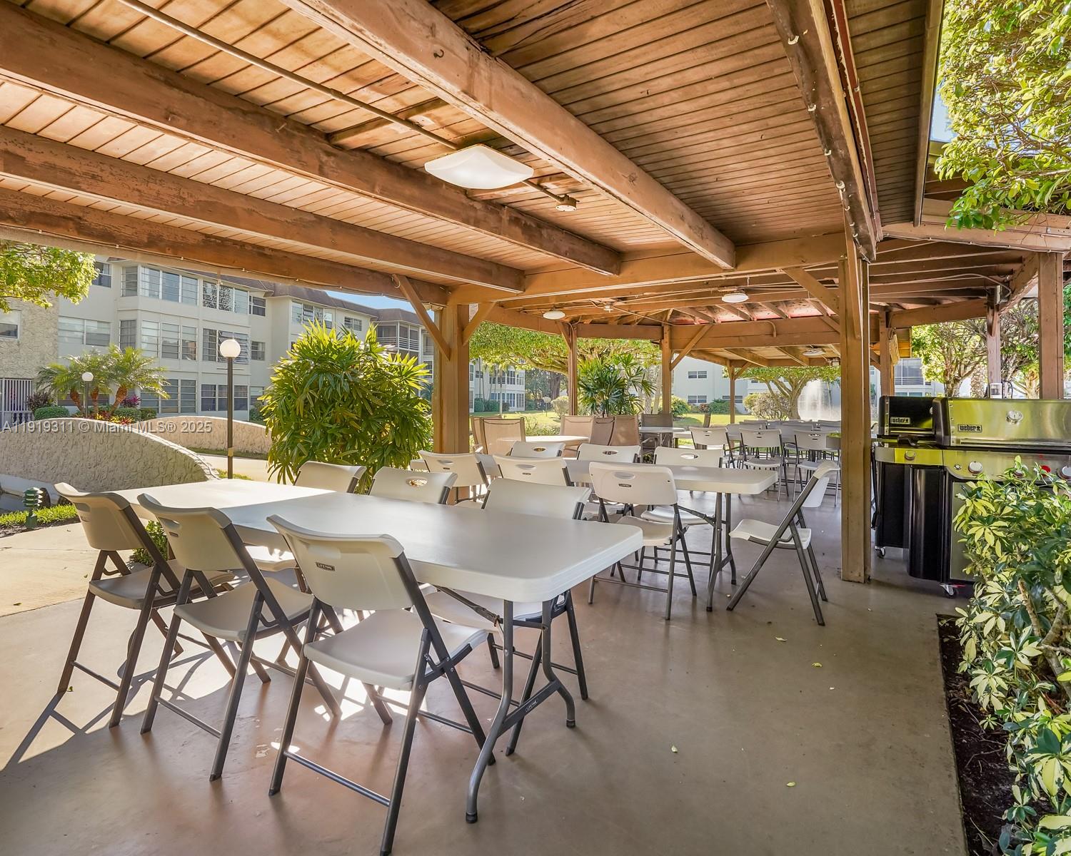 4705 Northwest 35th Street, Unit 616 Lauderdale Lakes, FL 33319 - Photo 30 of 33 a view of an outdoor dining space with a table and chairs