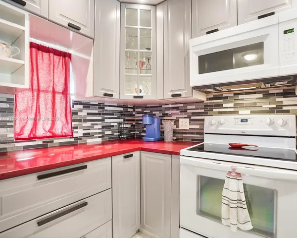 a kitchen with a stove and white cabinets