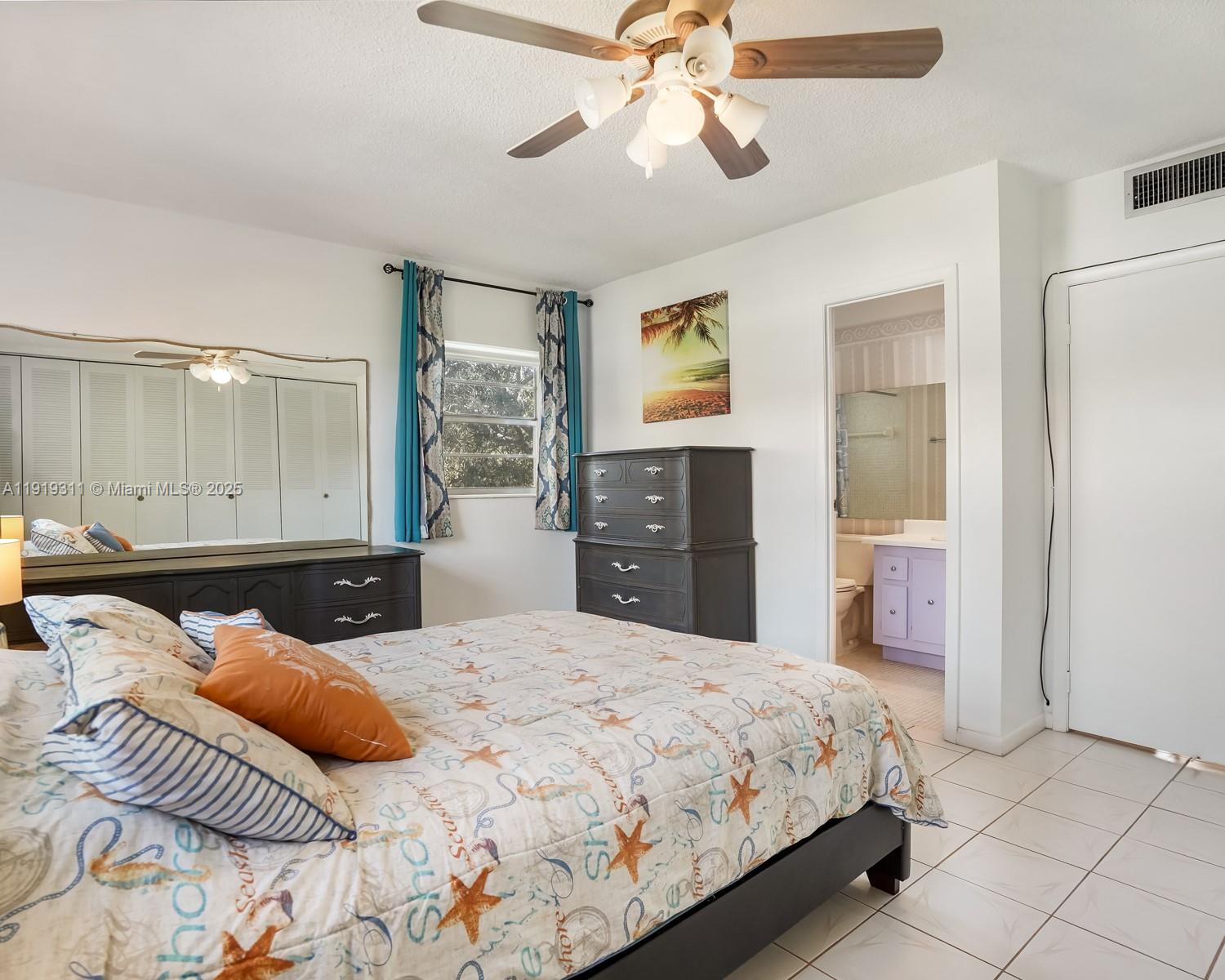 4705 Northwest 35th Street, Unit 616 Lauderdale Lakes, FL 33319 - Photo 9 of 33 a bedroom with a large bed and a chandelier