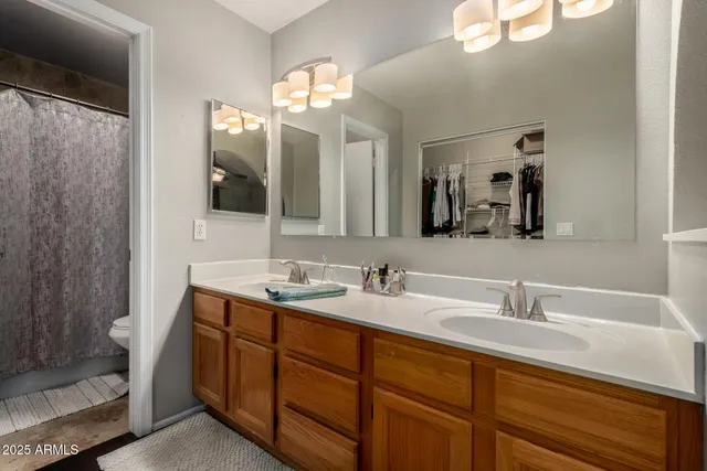 a bathroom with double vanity sinks and a mirror