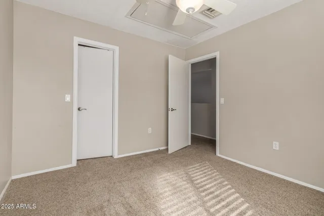 a view of an empty room with closet and entryway