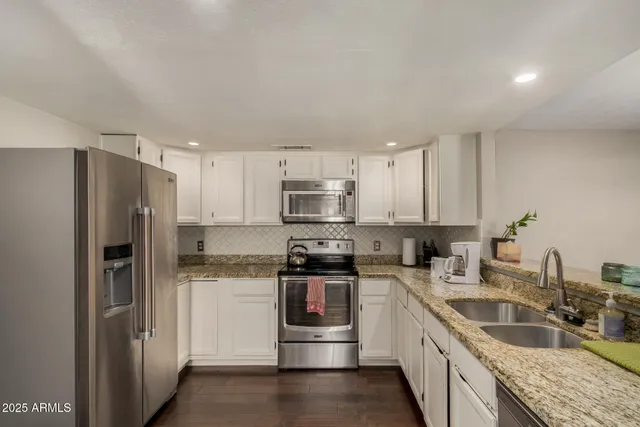 a kitchen with stainless steel appliances granite countertop a refrigerator and a sink