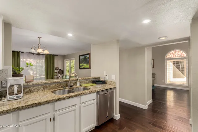 a kitchen with granite countertop a sink and a stove top oven