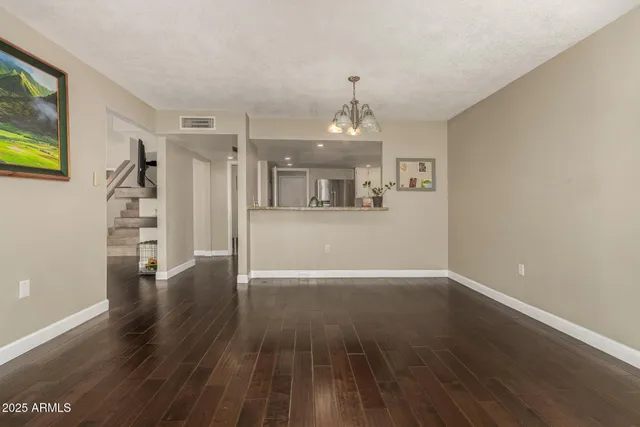 a view of a livingroom with wooden floor and stairs