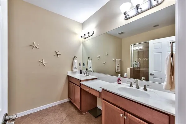 a bathroom with a sink double vanity granite and a mirror