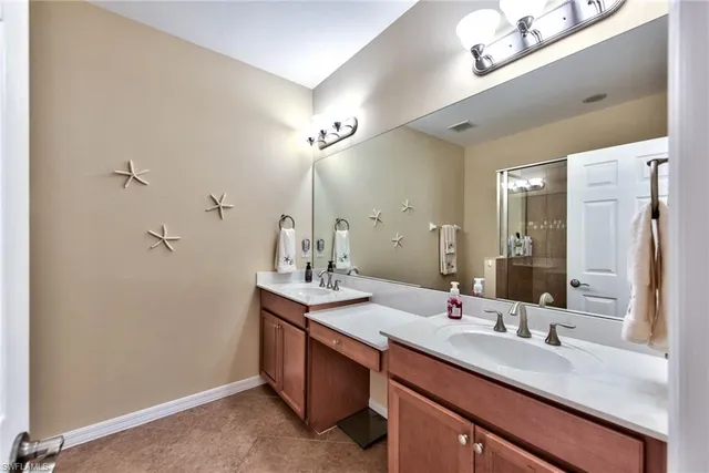 a bathroom with a sink double vanity granite and a mirror