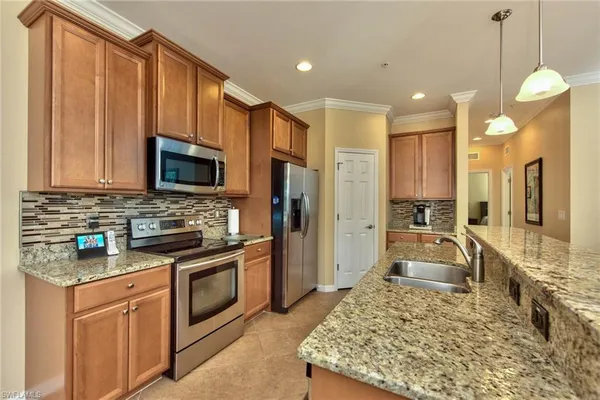 a large kitchen with kitchen island granite countertop a stove top oven a sink dishwasher a dining table and chairs
