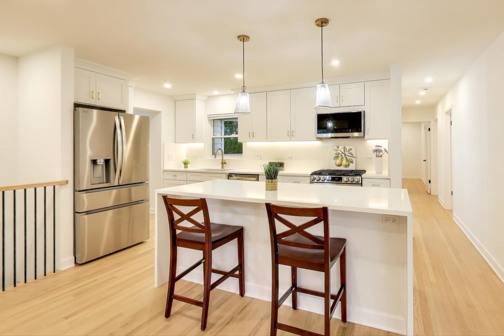 832 North Delphia Avenue Park Ridge, IL 60068 - Photo 4 of 29 a kitchen with stainless steel appliances kitchen island granite countertop a refrigerator a stove a microwave oven a dining table and chairs with wooden floor