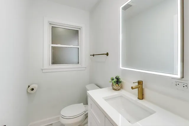 a bathroom with a sink a toilet and a mirror