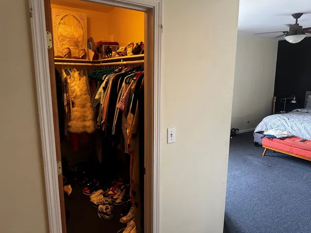 a view of walk in closet with clothes and shoes