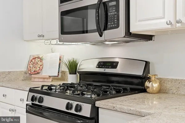 a kitchen with stainless steel appliances granite countertop a stove and a microwave