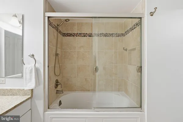 a bathroom with a granite countertop bathtub and a shower
