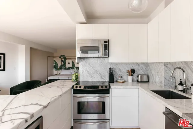 a kitchen with granite countertop cabinets stainless steel appliances and sink