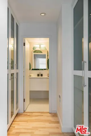a view of a hallway with bathroom and mirror
